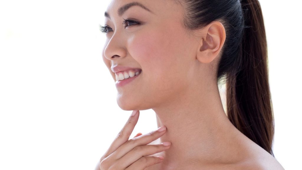 A woman smiles after her double chin treatment