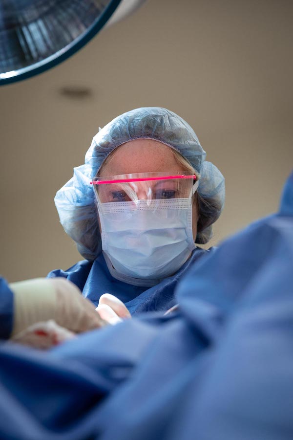 A surgeon performs a double chin removal