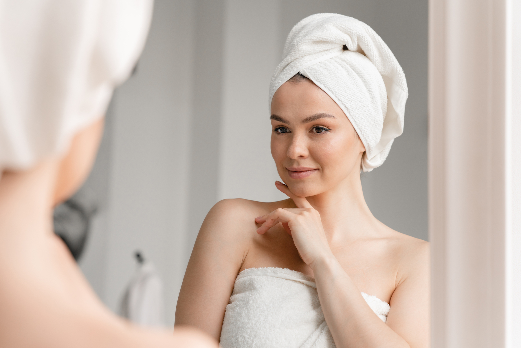A woman smiles, enjoying her radiant glow after consistent microneedling near Westfield.