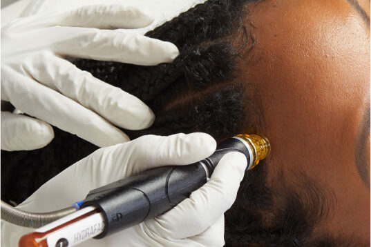 A provider applies the device to a patient's forehead during her Hydrafacial near Westfield.